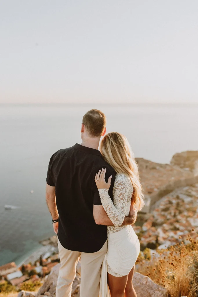 portrait photo of engaged couple looking at dubrovnik