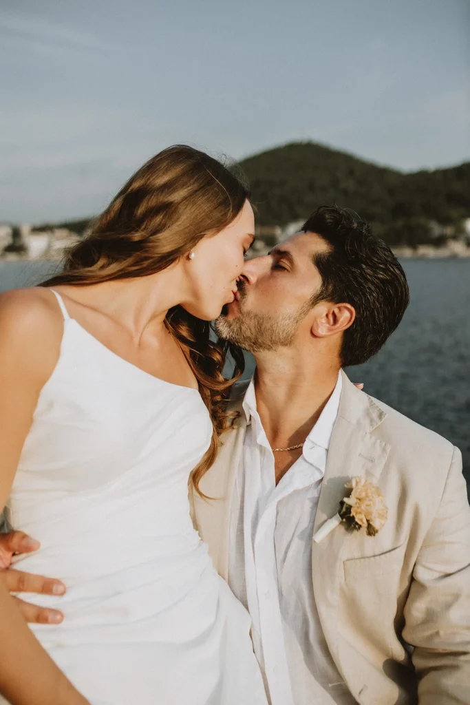husband kissing his wife near the sea